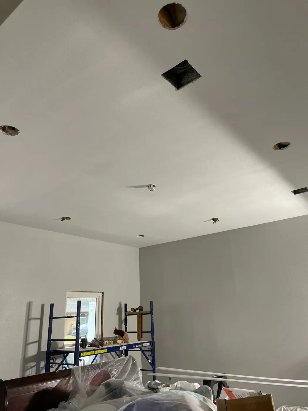 Recessed can light openings cut and wired in a vaulted ceiling during a Houma remodel