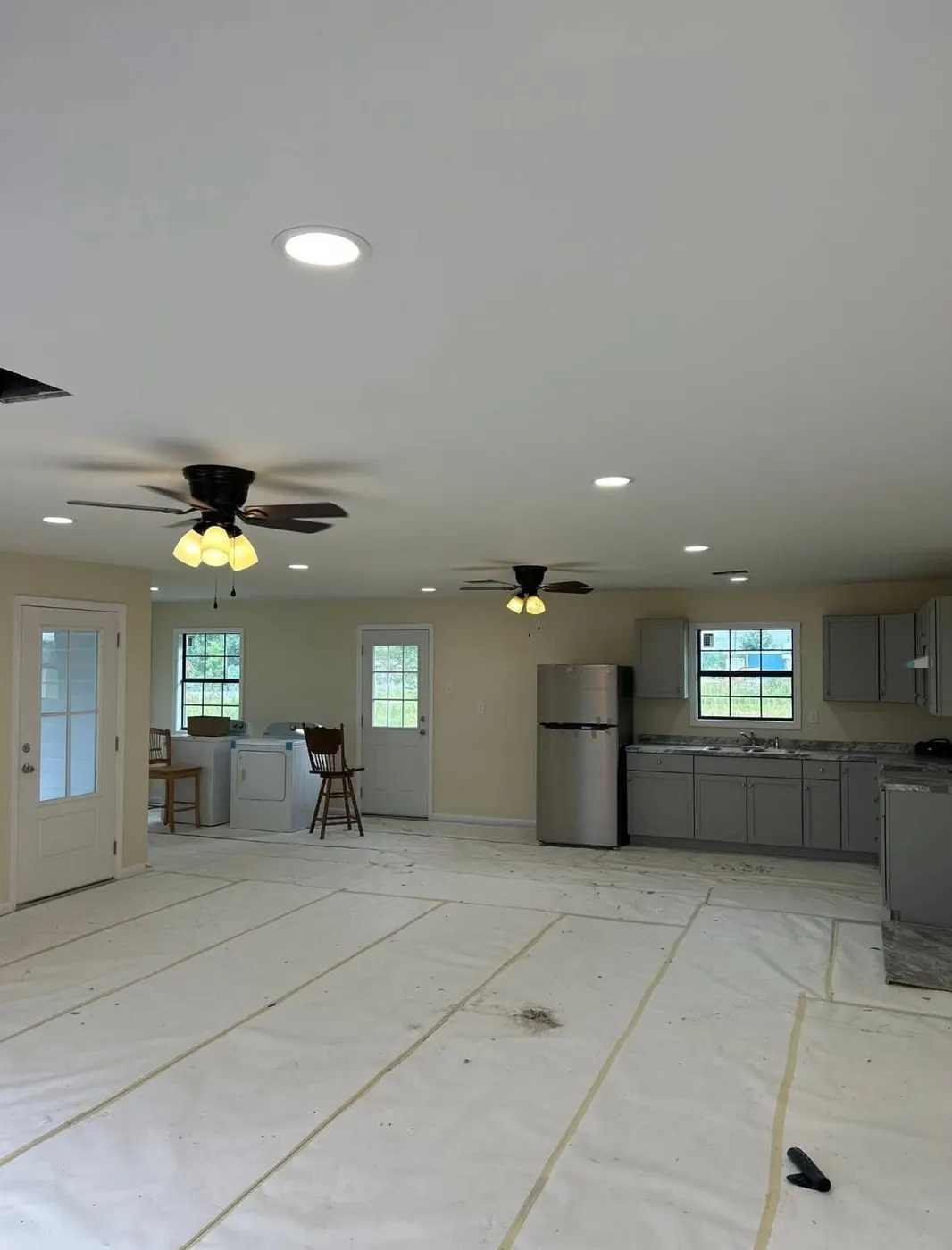 Bright remodeled living space with new recessed lighting and ceiling fans