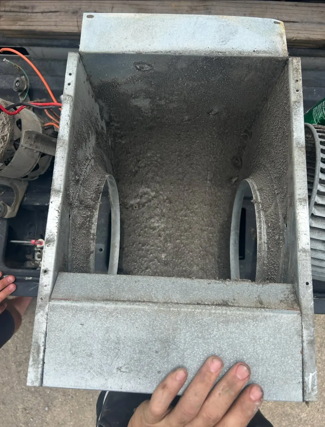Blower housing removed and caked with dust before a full system cleaning